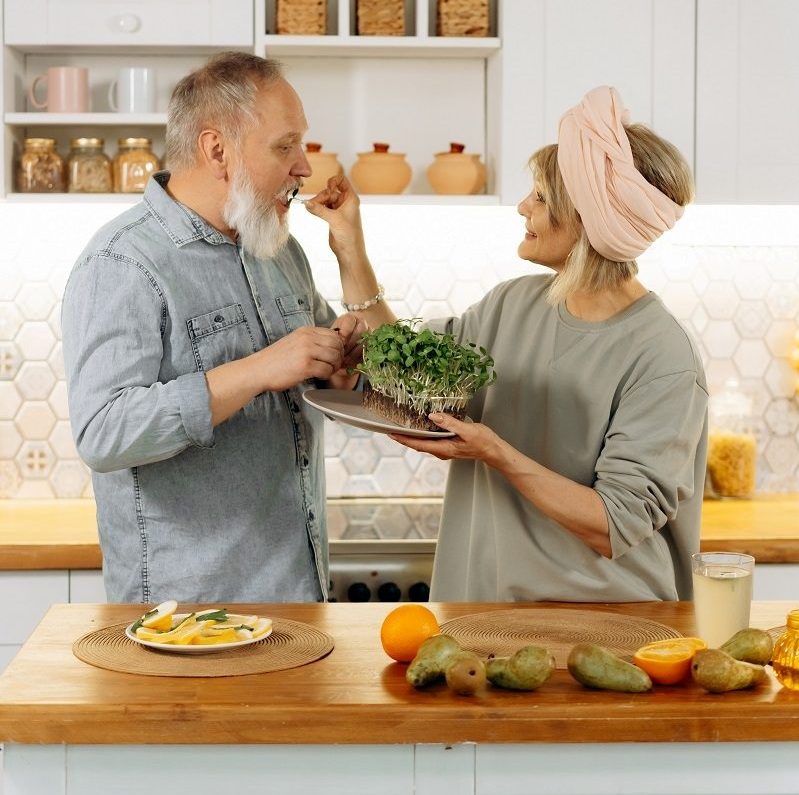 couple feeding each other in kitchen